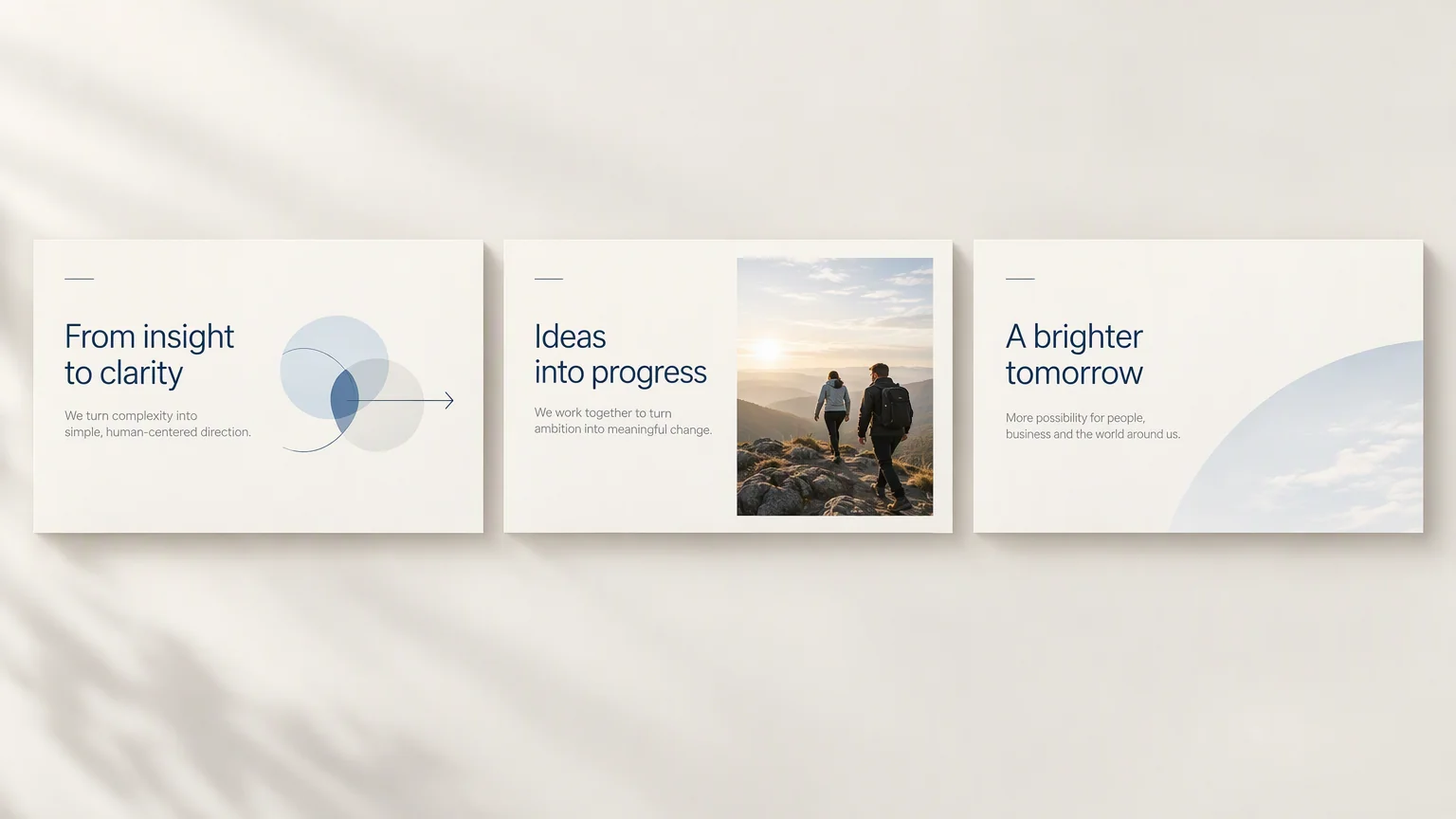 明るい壁に並んだ 3 枚のスライド。1 枚目は「From insight to clarity」、その下に「We turn complexity into simple, human-centered direction.」、右側には半透明の円が 3 つ重なり、右を指す矢印が添えられています。2 枚目は「Ideas into progress」、その下に「We work together to turn ambition into meaningful change.」、右半分には夜明けの岩稜を歩く 2 人の写真。3 枚目は「A brighter tomorrow」、その下に「More possibility for people, business and the world around us.」、右端から淡い青の弧が流れ込んでいます。